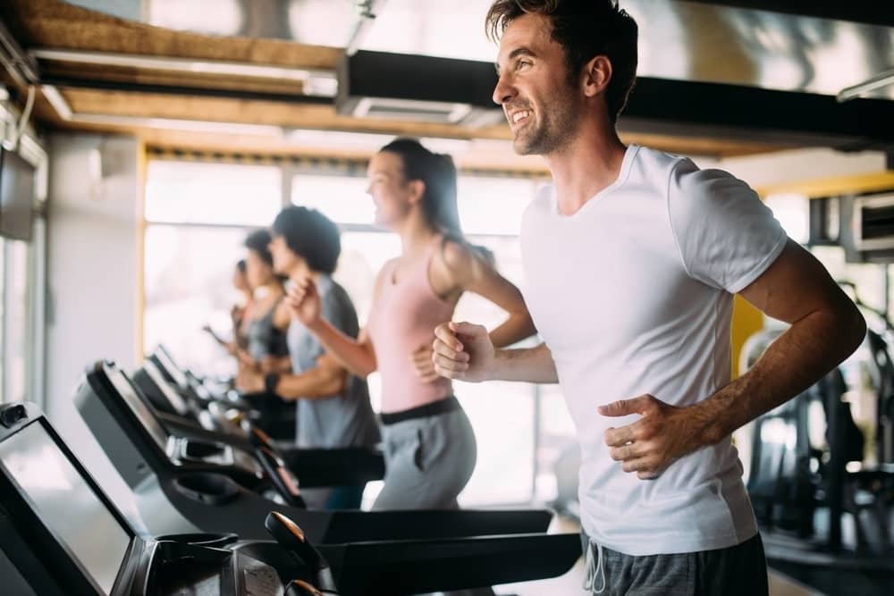 Stock photograph showing people exercising on treadmills in a gymnasium.
